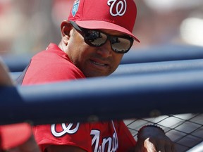 File-This March 15, 2018, file photo shows Washington Nationals manager Dave Martinez looking on from the dugout a spring training baseball game against the Houston Astros in West Palm Beach, Fla. And once again, the team in the nation's capital is not only coming off an NL East title but an opening-round playoff exit, so it heads to Game 1 with a new manager, this time rookie Martinez, charged with finally creating some postseason success.