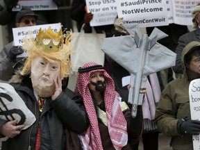 Protesters, some dressed as U.S. President Donald Trump and Crown Prince Mohammed bin Salman, stand on the steps of City Hall in New York, Tuesday, March 20, 2018.