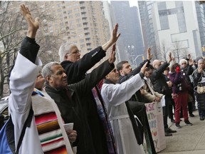 Clergy members and other supporters of the New Sanctuary Coalition pray in front of the Trump International Hotel in New York, Thursday, March 29, 2018. People gathered to show support for Aura Hernandez, an undocumented immigrant that has taken sanctuary in a church to prevent her from being deported and separated from her family. After praying at the hotel, supporters walked to the church where they washed Hernandez feet, recreating the moment when when Jesus washed his apostles' feet.