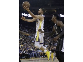 Golden State Warriors guard Stephen Curry, left, shoots in front of Brooklyn Nets forward Rondae Hollis-Jefferson during the first half of an NBA basketball game in Oakland, Calif., Tuesday, March 6, 2018.