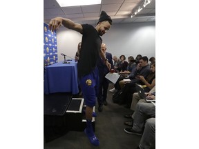 Golden State Warriors guard Stephen Curry walks down a step after speaking at a news conference before an NBA basketball game between the Warriors and the Utah Jazz in Oakland, Calif., Sunday, March 25, 2018.