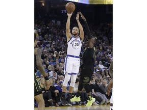 Golden State Warriors guard Stephen Curry (30) shoots against Atlanta Hawks guard Dennis Schroeder during the first half of an NBA basketball game in Oakland, Calif., Friday, March 23, 2018.