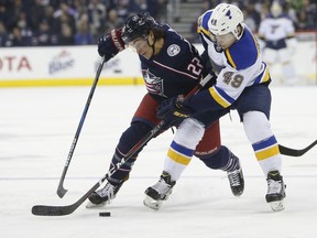 Columbus Blue Jackets' Sonny Milano, left, and St. Louis Blues' Ivan Barbashev, right, of Russia, fight for a loose puck during the first period of an NHL hockey game Saturday, March 24, 2018, in Columbus, Ohio.