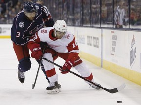 Detroit Red Wings' Andreas Athanasiou, right, carries the puck upice as Columbus Blue Jackets' Seth Jones defends during the third period of an NHL hockey game Friday, March 9, 2018, in Columbus, Ohio.