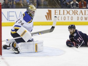St. Louis Blues' Jake Allen, left, makes a save against Columbus Blue Jackets' Nick Foligno during the second period of an NHL hockey game Saturday, March 24, 2018, in Columbus, Ohio.