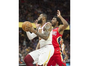 Cleveland Cavaliers' LeBron James (23) drives past New Orleans Pelicans' Solomon Hill (44) on the way to score a basket during the first half of an NBA basketball game in Cleveland, Friday, March 30, 2018. James broke Michael Jordan's NBA record by scoring at least 10 points in his 867th straight regular-season game.