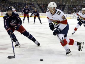 Florida Panthers defenseman Mike Matheson, right, controls the puck against Columbus Blue Jackets defenseman Zach Werenski during the first period of an NHL hockey game in Columbus, Ohio, Thursday, March 22, 2018.