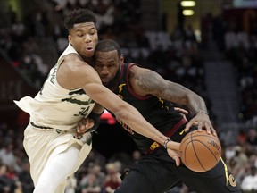 Milwaukee Bucks' Giannis Antetokounmpo, left, from Greece, knocks the ball loose from Cleveland Cavaliers' LeBron James in the first half of an NBA basketball game, Monday, March 19, 2018, in Cleveland.