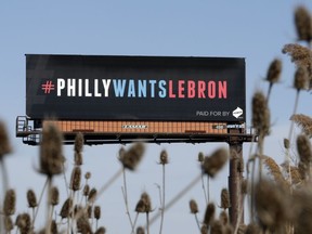One of three billboards trying to entice Cleveland Cavaliers' LeBron James to come to Philadelphia are shown near a highway, Tuesday, Feb. 27, 2018, in Cleveland. The three billboards were unveiled on Monday on busy Interstate-480 outside Cleveland, and each contains a message asking James to sign with the Sixers this summer as a free agent. Although James may not see the signs because they're not on any route he would take from his home in Bath, Ohio, to Quicken Loans Arena, the three-time champion was warmed by their sentiment.