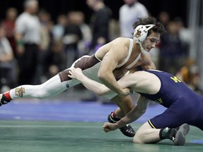 Lehigh's Darian Cruz, top, grapples with Michigan's Drew Mattin during the 125-pound weight class match of the NCAA Division I Wrestling Championships, Thursday, March 15, 2018, in Cleveland. Cruz won the match.