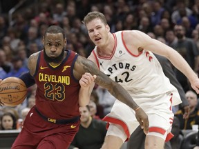 Cleveland Cavaliers' LeBron James (23) drives past Toronto Raptors' Jakob Poeltl (42) during the second half of an NBA basketball game Wednesday, March 21, 2018, in Cleveland. The Cavaliers won 132-129.