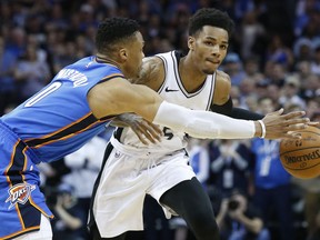 Oklahoma City Thunder guard Russell Westbrook (0) reaches for the ball as San Antonio Spurs guard Dejounte Murray, right, dribbles in the first half of an NBA basketball game in Oklahoma City, Saturday, March 10, 2018.