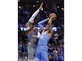 Los Angeles Clippers forward Tobias Harris (34) shoots as Oklahoma City Thunder center Steven Adams, left, defends during the first half of an NBA basketball game in Oklahoma City, Friday, March 16, 2018.