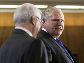 Ontario PC Leader Doug Ford (right) stands with former interim leader Vic Fedeli while taking questions from journalists during a pre-budget lock-up, as the Ontario Provincial Government prepares to deliver its 2018 Budget at the Queens Park Legislature in Toronto, on Wednesday, March 28, 2018.