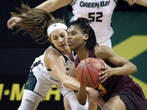 Green Bay's Laken James, left, battles Minnesota's Kenisha Bell for a loose ball during first quarter of a first-round game at the NCAA women's college basketball tournament in Eugene, Ore., Friday, March 16, 2018.