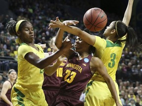 Oregon's Ruthy Hebard, left, and Justine Hall, right, battle Minnesota's Kenisha Bell for a loose ball during the second quarter of a second-round game in the NCAA women's college basketball tournament in Eugene, Ore., Sunday, March 18, 2018.