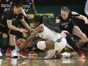 Seattle's Kamira Sanders, left, and Jacinta Beckley, right, battle Oregon's Ruthy Hebard, center, for a loose ball during the first half of an NCAA women's college basketball tournament first-round game in Eugene, Ore., Friday, March 16, 2018.