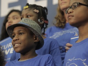 This photo taken March 20, 2016, shows Devonte Hart at then Democratic presidential candidate Bernie Sanders visiting Hudson's Bay High School in Vancouver, Wash. Hart is one of three children who are missing after their siblings and parents were killed when their SUV plunged off a California cliff. Hart had gained fame when a picture of him hugging a white police officer during a protest went viral.