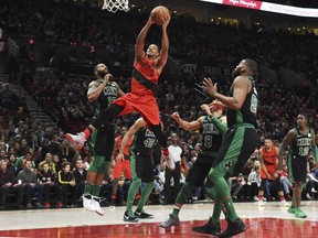 Portland Trail Blazers guard CJ McCollum drives to the basket against, from left to right, Boston Celtics forward Marcus Morris, forward Al Horford, guard Shane Larkin, center Greg Monroe and guard Terry Rozier during the first half of an NBA basketball game in Portland, Ore., Friday, March 23, 2018.