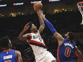 Portland Trail Blazers forward Ed Davis, right, drives to the basket on Detroit Pistons center Andre Drummond as Pistons forward Stanley Johnson, left, watches during the second half of an NBA basketball game in Portland, Ore., Saturday, March 17, 2018. The Blazers won 100-87.