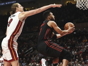 Portland Trail Blazers forward Evan Turner drives to the basket past Miami Heat forward Kelly Olynyk during the second half of an NBA basketball game in Portland, Ore., Monday, March 12, 2018. The Blazers won 115-99.