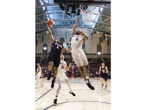 Pennsylvania's Darnell Foreman, left, goes up for the shot with Harvard's Chris Lewis, right, defending the basket during the first half of an NCAA college basketball championship game in the Ivy League tournament, Sunday, March 11, 2018, in Philadelphia.