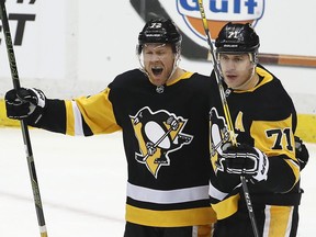 Pittsburgh Penguins' Patric Hornqvist (72) celebrates his goal with Evgeni Malkin (71) in the first period of an NHL hockey game against the Montreal Canadiens in Pittsburgh, Saturday, March 31, 2018.