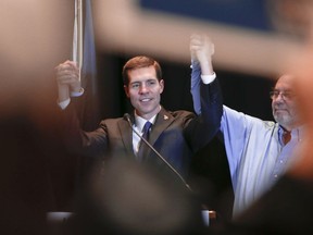 Democrat Conor Lamb, left, links arms with United Steelworkers President Leo Gerard, right, and Pennsylvania Gov. Tom Wolf, left, not visible, during a campaign rally at the United Steelworkers headquarters in Pittsburgh, Friday, March 9, 2018. Lamb is running against Republican Rick Saccone in a special election being held on March 13 for the PA 18th Congressional District vacated by Republican Tim Murphy.