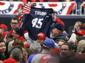 Supporters wave a jersey supporting President Donald Trump before he arrives for a campaign rally for Republican Rick Saccone, Saturday, March 10, 2018, in Moon Township, Pa. Saccone is running against Democrat Conor Lamb in a special election being held on March 13 for the Pennsylvania 18th Congressional District vacated by Republican Tim Murphy.