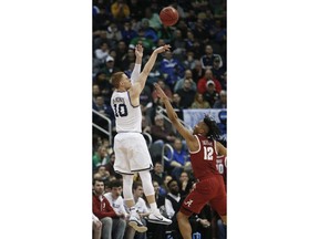 Villanova's Donte DiVincenzo (10) hits a 3-point shot over Alabama's Dazon Ingram (12) during the first half of a second-round game in the NCAA men's college basketball tournament, Saturday, March 17, 2018, in Pittsburgh.