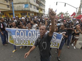 Demonstrators shout slogans holding a banner with a message that reads in Spanish: "Colon united for the cause" in Colon, Panama, Tuesday, March 13, 2018. A protest turned into violent clashes with police in Colon, which is home to a strategic port at the northern end of the country's interoceanic canal. Demonstrators are angry over what they see as the slow pace of a multimillion-dollar plan to revitalize Colon's collapsed sewer system, water supply and housing.