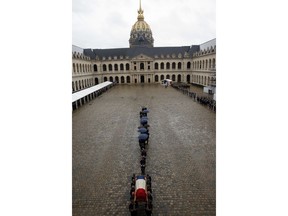 Soldiers carry the coffin of Lt. Col. Arnaud Beltrame, Wednesday March 28, 2018 in the courtyard of the Hotel des Invalides in Paris. The slain hero of last week's extremist attack in southern France will be posthumously awarded the Legion of Honor by French President Emmanuel Macron during a solemn day-long national homage to him.