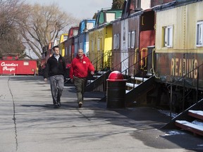 In a March 13, 2018 photo, Tyler Prickett, left, and his father Todd walk past a row of cabooses at the Red Caboose Motel and Restaurant in Ronks, Pa. The father-son team bought the complex of railroad cars in 2015.