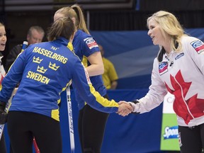 Canada skip Jennifer Jones shakes hands with Sweden skip Anna Hasselborg as Kaitlyn Lawes looks on following Canada's victory at the World Women's Curling Championship Wednesday, March 21, 2018 in North Bay, Ont.