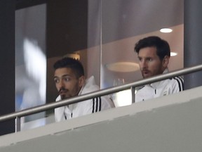 Lionel Messi, right, watches the international friendly soccer match between Spain and Argentina at the Wanda Metropolitano stadium in Madrid, Spain, Tuesday, March 27, 2018.
