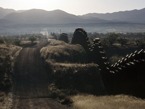 FILE - This April 2, 2017 file drone photo shows the U.S.-Mexico border fence on the outskirts of Nogales in southern Arizona. A U.S. border patrol agent is going on trial for second-degree murder in U.S. District Court in Tucson on Tuesday, March 20, 2018, in a rare Justice Department prosecution of a fatal cross-border Mexico shooting.