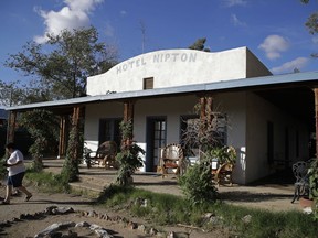 FILE - In this Aug. 3, 2017, file photo, a woman walks out of the Hotel Nipton in Nipton, Calif. A Phoenix-based marijuana technology company bought the town of Nipton for $5 million with ambitious plans to turn its dusty, nearly deserted 80 acres into a pot-friendly resort destination just an hour outside Las Vegas. But the company announced earlier in March 2018 it has sold Nipton to Delta International Oil & Gas in a cash and stock deal worth about $7.7 million.