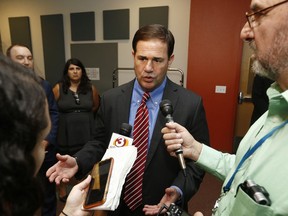 FILE - In this Aug. 24, 2017, file photo, Arizona Republican Gov. Doug Ducey speaks to the media about school choice and the voucher system after touring the Arizona School for the Arts, in Phoenix. On Wednesday, March 21, 2018, public school supporters won a major victory in their bid to block Arizona's massive school voucher expansion law when the state Supreme Court ruled voters could decide the issue in November.