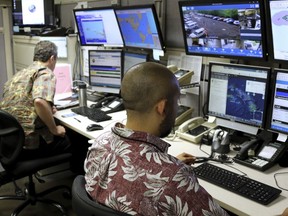 FILE - In this Dec. 1, 2017 file photo, Hawaii Emergency Management Agency officials work at the department's command center in Honolulu. The Honolulu Police Department is releasing a sampling of 911 calls made after a cellphone and broadcast alert mistakenly warned of a ballistic missile headed to Hawaii.