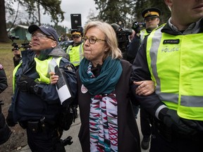 Federal Green Party Leader Elizabeth May, centre, is arrested by RCMP officers after joining protesters outside Kinder Morgan's facility in Burnaby, B.C., on Friday March 23, 2018. Protesters have been gathering all week - defying a court order - to protest the Kinder Morgan Trans Mountain pipeline expansion. The pipeline is set to increase the capacity of oil products flowing from Alberta to the B.C. coast to 890,000 barrels from 300,000 barrels.