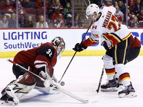 Arizona Coyotes goaltender Antti Raanta (32) makes a save on a shot by Calgary Flames center Sean Monahan (23) during the first period of an NHL hockey game Monday, March 19, 2018, in Glendale, Ariz.