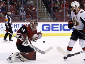 Arizona Coyotes goaltender Antti Raanta (32) makes a save on a shot as Ottawa Senators left wing Zack Smith, right, looks on during the first period of an NHL hockey game Saturday, March 3, 2018, in Glendale, Ariz.