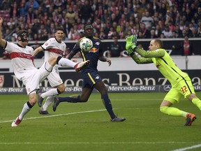 Stuttgart's Christian Gentner, left, and Leipzig's goal keeper Peter Gulacsi fight for the ball during a German Bundesliga socer match between VfB Stuttgart and RB Leipzig in Stuttgart, Germany, Sunday, March 11, 2018.