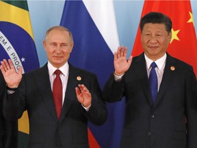 Chinese President Xi Jinping, right,  and Russian President Vladimir Putin, left, pose for a group photo during the Emerging Market and Developing Countries meeting at the BRICS Summit, in Xiamen, China, Tuesday, Sept. 5, 2017