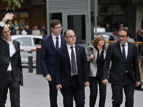 FILE - In this Nov. 2, 2017 file photo, fired Catalan Cabinet member Jordi Turull, center, arrives with other former Cabinet members at the national court in Madrid, Spain. The Catalan Parliament speaker has set a Thursday March 22, 2018 vote in the afternoon to elect as the next regional president, a former separatist minister who could be indicted on rebellion charges only one day after. Speaker Roger Torrent made a hastily called appearance in the regional parliament to announce that Jordi Turull, the former chief of the Catalan Presidency, has the widest support to be voted in as the Spanish region's next president. From left to right are former Cabinet members Raul Romeva, Carles Mundo, Jordi Turull, Meritxell Borras and Josep Rull.