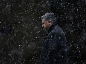 A man walks through falling snow Tuesday, March 20, 2018, in Philadelphia. The National Weather Service says a powerful storm packing heavy, wet snow and strong winds could dump up to 18 inches of snow in some locations on Wednesday.