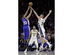 Philadelphia 76ers' Markelle Fultz (20) goes up for a shot against Denver Nuggets' Mason Plumlee (24) as Jamal Murray (27) looks on during the first half of an NBA basketball game, Monday, March 26, 2018, in Philadelphia.