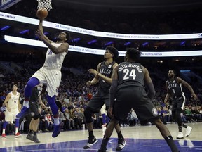 Philadelphia 76ers' Joel Embiid (21) goes up to dunk as Brooklyn Nets' Jarrett Allen (31), Rondae Hollis-Jefferson (24) and DeMarre Carroll (9) look on during the first half of an NBA basketball game, Friday, March 16, 2018, in Philadelphia.