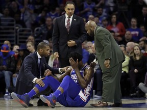 Philadelphia 76ers' Joel Embiid, center, lies not he court after an injury during the first half of an NBA basketball game against the New York Knicks, Wednesday, March 28, 2018, in Philadelphia.