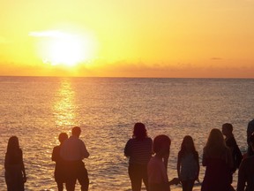 People watch the sunset from the beach at Captiva, Florida.